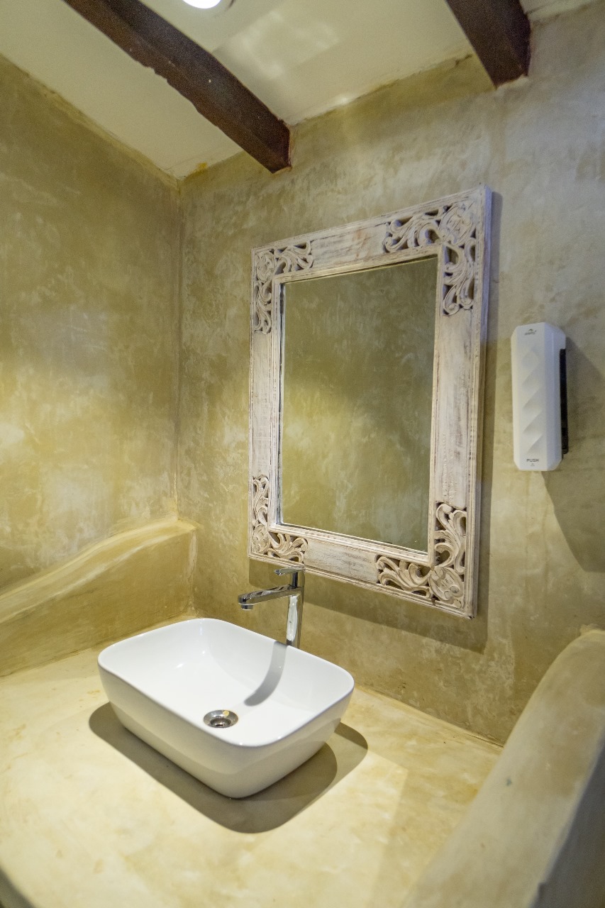 Rustic bathroom with carved mirror